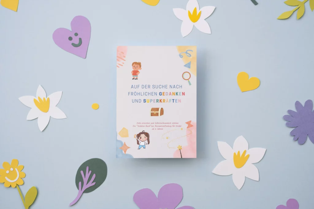 Arbeitsbuch „Auf der Suche nach fröhlichen Gedanken und Superkräften“ zwischen Papierblumen