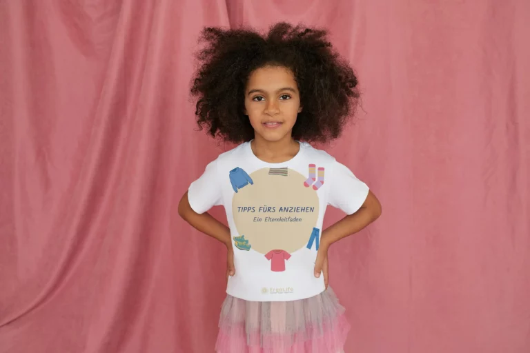 Mädchen mit Locken trägt ein T-Shirt mit dem Aufdruck „Tipps fürs Anziehen“