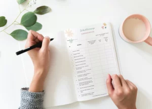 Hände füllen die Checkliste „Achtsam durch den Alltag“ aus, daneben eine Tasse