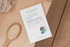 Blatt „Achtsam durch den Alltag“ neben einer Haarbürste auf einem Holztisch