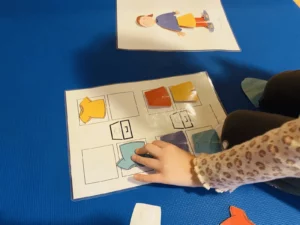 Kind legt in der TEACCH-Aufgabenmappe Kleidungskarten an die richtige Stelle