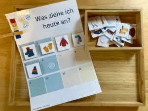 Anziehplan „Was ziehe ich heute an?“ mit Bildkarten in einer Holzkiste