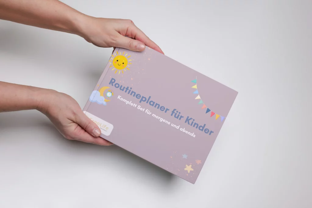 Hände halten den Routineplaner für Kinder