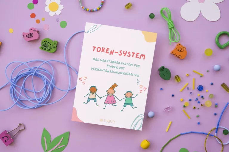 Heft „Token-System“ auf lila Hintergrund mit Bastelmaterial